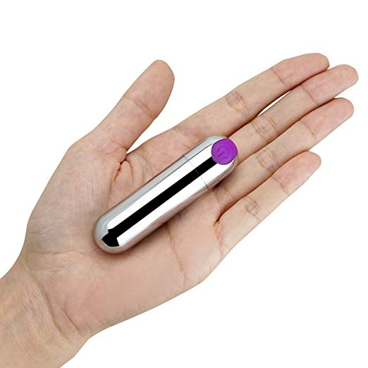 Small cylindrical device with a purple end held in a hand on a white background