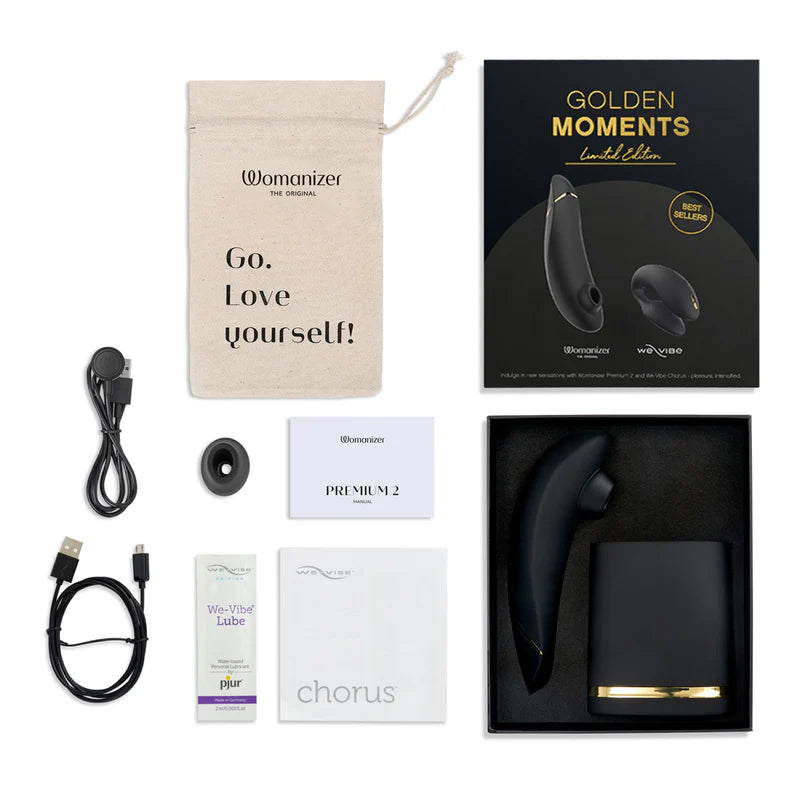 Womanizer product set with packaging, USB cable, and accessories on a white background